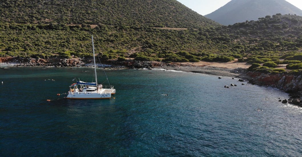 Our catamaran near a beach during the Catamaran Trip to Rethymno with Lunch & Snorkeling with The Skippers Bali.
