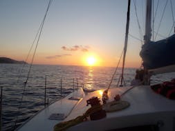 Le magnifique coucher de soleil illumine notre catamaran lors de la Balade en catamaran au coucher du soleil autour de la baie de Bali avec Snorkeling avec The Skippers Bali.