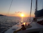 Uno splendido tramonto illumina il catamarano durante il Giro in catamarano al tramonto nella baia di Bali con snorkeling con The Skippers - Boats & Water Sports Bali.
