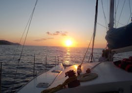 Le magnifique coucher de soleil illumine notre catamaran lors de la Balade en catamaran au coucher du soleil autour de la baie de Bali avec Snorkeling avec The Skippers Bali.