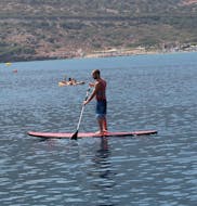 A man is paddling during the SUP Hire at Bali on Crete with The Skippers Bali.
