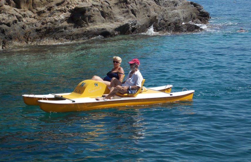 Two old people are spending a peaceful moment together on the pedal boat during the Pedal Boat at Bali on Crete with The Skippers Bali.