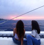 Deux amis admirant le coucher de soleil lors d'une balade en catamaran au départ de Jávea sur la Costa Blanca avec Mundo Marino.