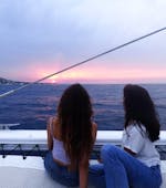 Dos amigos admirando la puesta de sol durante una excursión en catamarán desde Jávea por la Costa Blanca con Mundo Marino.