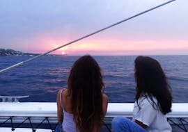 Due amici ammirano il tramonto durante una gita in catamarano da Jávea lungo la Costa Blanca con Mundo Marino.