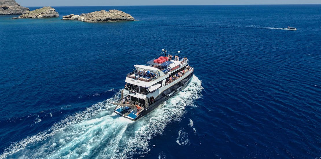 The boat "Discovery" navigates on the Mediterranean Sea during the Full-Day Boat Trip to Lindos with Swimming with Rizos Cruises Rhodes.