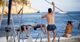 Unos amigos se bañan en el mar Mediterráneo durante un paseo en catamarán en Valencia con baño con Mundo Marino.