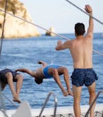 Friends take a swim in the Mediterranean Sea during a catamaran trip in Valencia with Mundo Marino.