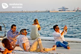 Un grupo de personas disfruta de la puesta del sol durante un paseo en catamarán al atardecer en Altea con Mundo Marino.