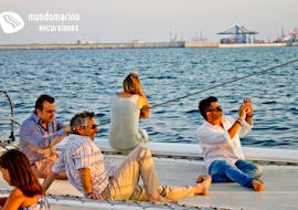 Un gruppo di persone ammira il tramonto durante un'escursione in catamarano ad Altea con Mundo Marino.