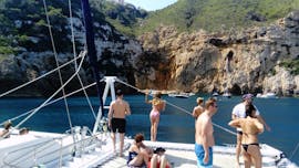 A group of people visit the coves and caves of Calpe during a catamaran trip from Calpe with BBQ & swimming with Mundo Marino.