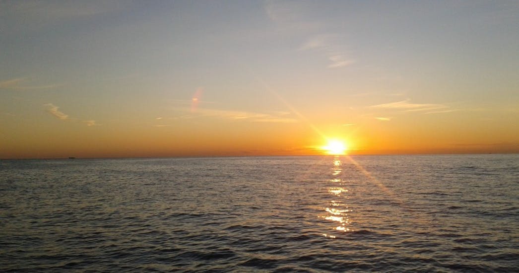 View of the sun setting on the horizon during a sunset catamaran trip from Calpe with Cava.