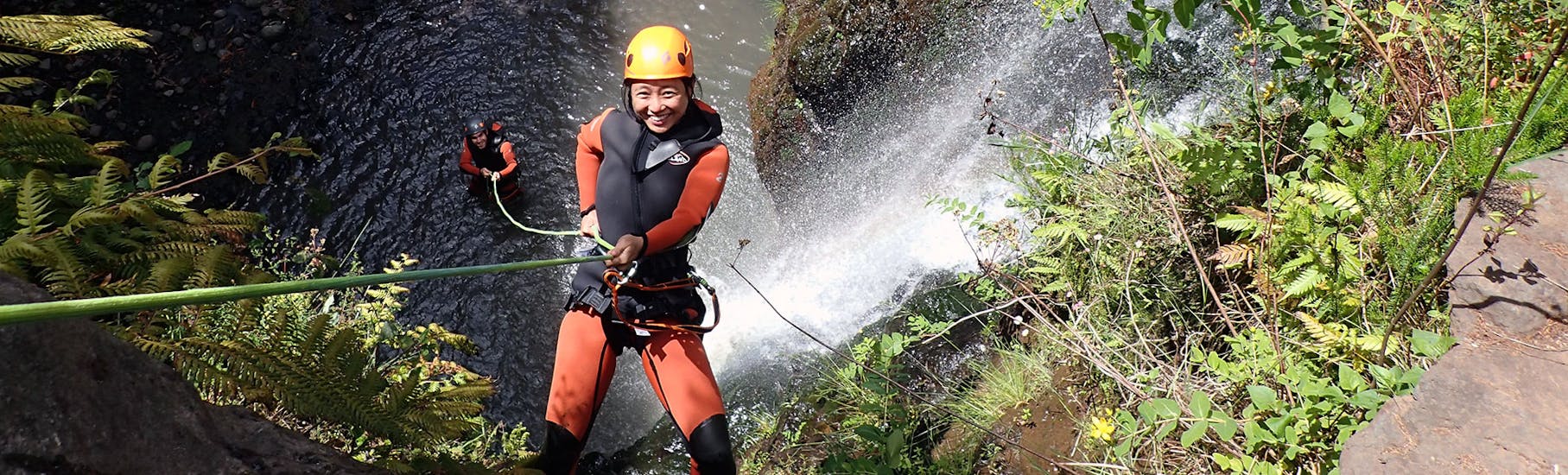 A woman is doing abseiling during the Canyoning in Madeira for Beginners & Families with Lokoloko Madeira.