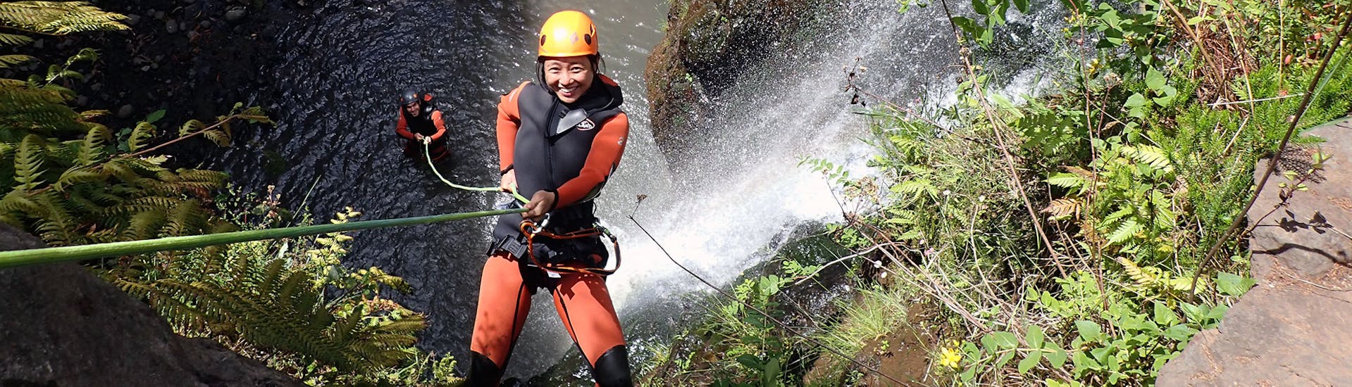 A woman is doing abseiling during the Canyoning in Madeira for Beginners & Families with Lokoloko Madeira.