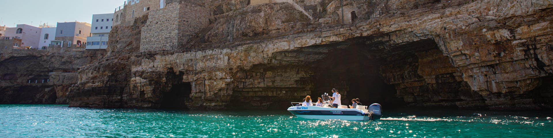The Blue Wave boat coasting Polignano a Mare Caves during the Boat Trip to Polignano a Mare Caves with Apéritif with Blue Wave.