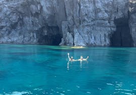 Deux personnes en train de nager pendant l'excursion en bateau semi-rigide autour de l'île de Sant'Antioco avec Snorkeling avec Blue Wave Sant'Antioco.