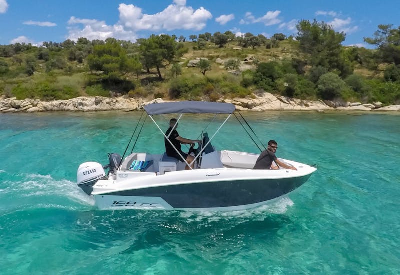 Alcune persone navigano intorno ad Halkidiki durante il Noleggio barca a Ormos Panagias (fino a 7 persone) senza patente con Luxury Sport Cruise Halkidiki.