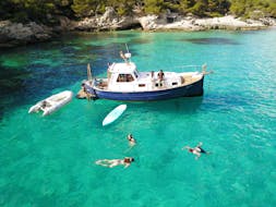 Teilnehmer, die ihre Bootstour mit Marenostrum Menorca von Cala Galdana nach Cala en Turqueta mit Aperitif und Schnorcheln im Wasser genießen.