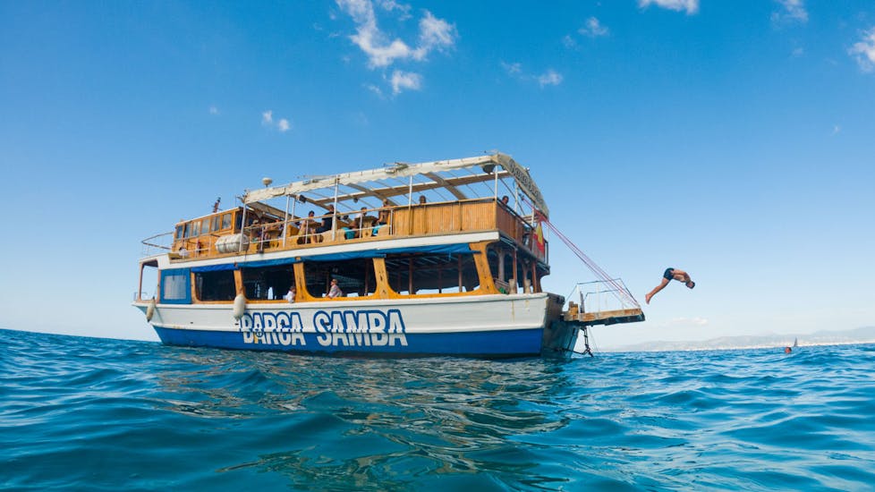 Una barca di Samba Boat che festeggia durante una gita in barca da Palma di Maiorca con DJ e pranzo incluso.