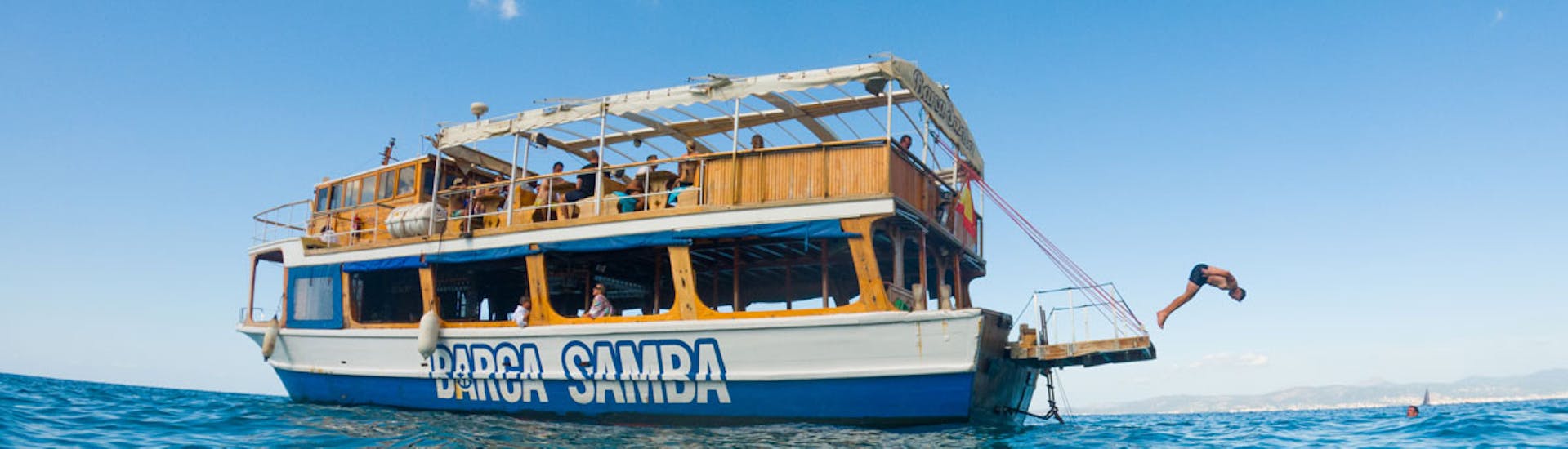 Una barca di Samba Boat che festeggia durante una gita in barca da Palma di Maiorca con DJ e pranzo incluso.