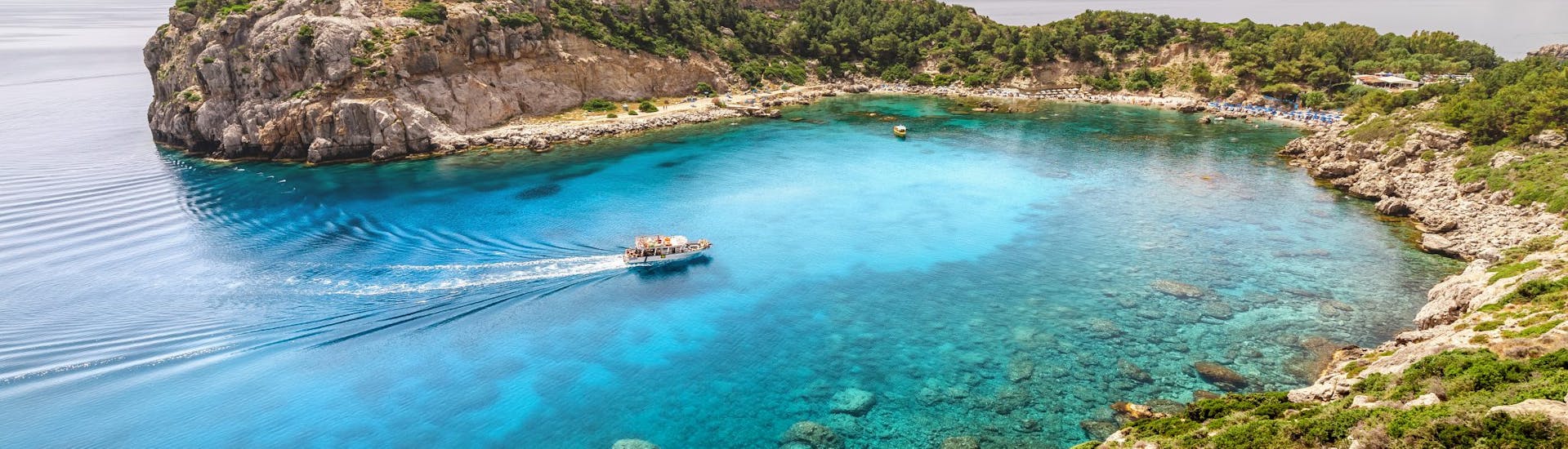 The boat is in the middle of Anthony Quinn Bay, one of the stops during the Boat Trip to Antony Quinn Bay, Traganou Caves & Kallithea with Snorkeling with Rizos Cruises Rhodes.