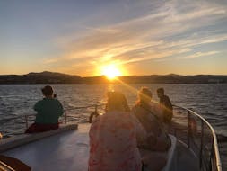 Personen die am Boot sitzen und den Sonnenuntergang beobachten während der Bootstour von Faliraki zur Anthony Quinn Bay mit Schwimmen bei Sonnenuntergang mit Sofia Sea Cruises Faliraki.