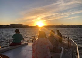 Personen die am Boot sitzen und den Sonnenuntergang beobachten während der Bootstour von Faliraki zur Anthony Quinn Bay mit Schwimmen bei Sonnenuntergang mit Sofia Sea Cruises Faliraki.