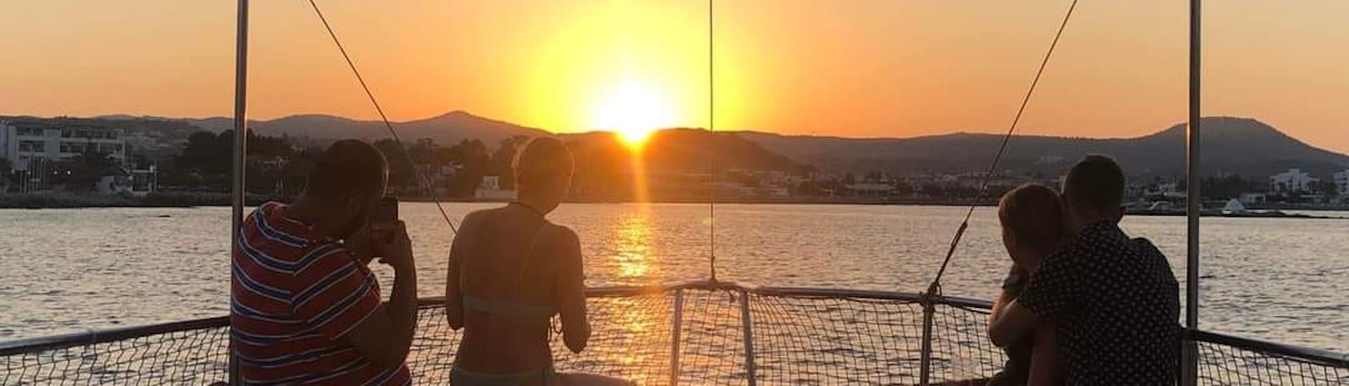 People sitting on the boat watching the sunset during the Sunset Boat Trip from Faliraki to Anthony Quinn Bay with Snorkeling with Sofia Sea Cruises Faliraki.