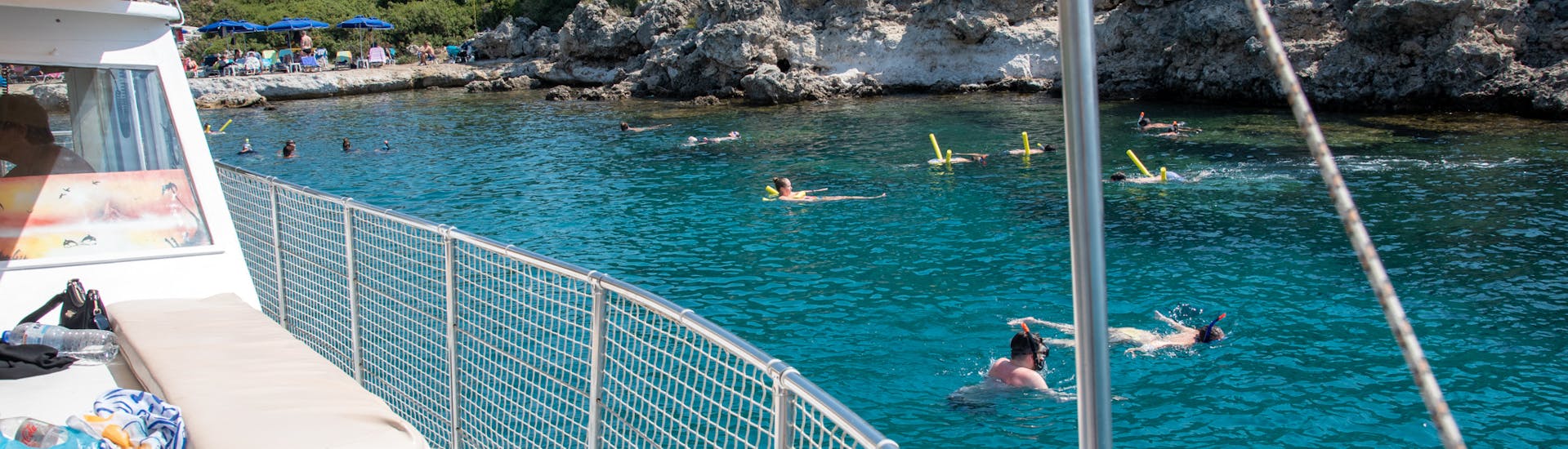 People swimming in turquoise blue water during the Private Boat Trip from Faliraki to Anthony Quinn Bay with Snorkeling with Sofia Sea Cruises Faliraki.