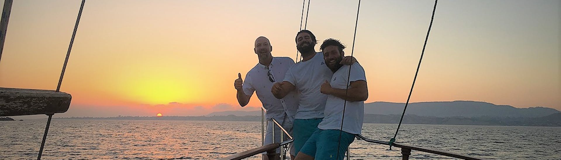 Drei Freunde genießen ihre Zeit auf der Queen Bee bei der Bootstour bei Sonnenuntergang zu den White Rocks & Xi Beach mit Abendessen.