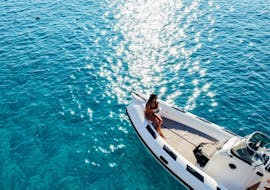 Una chica tomando el sol durante la excursión en barco semirrígido de Sant'Antioco a la isla de San Pietro con snorkel con Blue Wave Sant'Antioco.