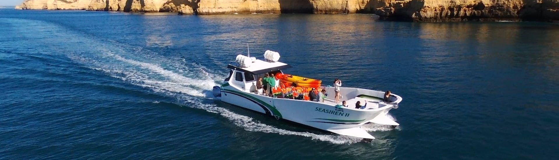 Catamaran naviguant lors de la Balade privée en catamaran aux grottes de Benagil & la plage de Marinha avec Kayak avec Seasiren Tours Algarve.