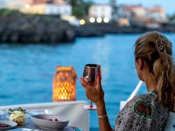 Una signora che si gode il Giro al tramonto in barca privata da Catania al Castello di Aci con aperitivo con Wish Boat Rent Catania.