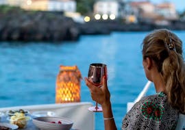 Een vrouw geniet van de Privéboottocht bij zonsondergang van Catania naar het kasteel van Aci met aperitief met Wish Boat Rent Catania.