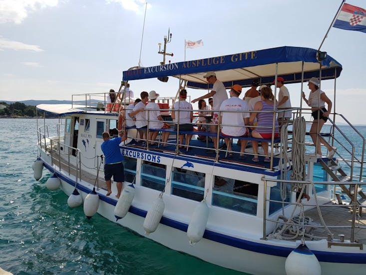 Un gruppo di persone si diverte durante la Gita in barca a Kormat, la Grotta Azzurra e la spiaggia di Golden Bay con snorkeling con Kapetan Nemo & Mali Pin Krk.
