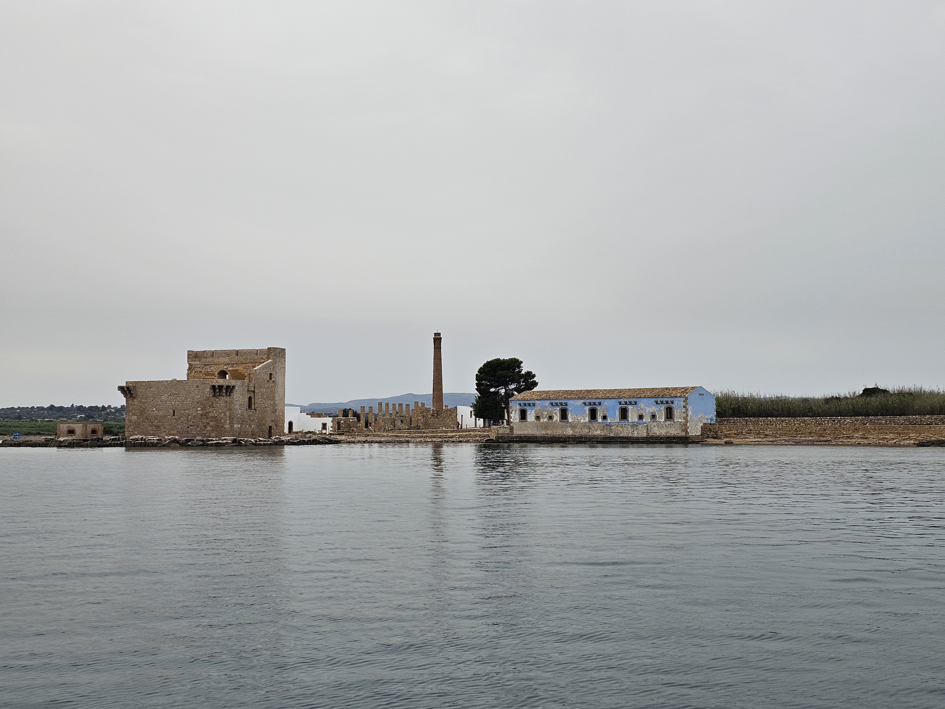 Antigua pesquería de atún de Marzamemi vista desde un paseo en barco. Los edificios históricos de piedra de la Tonnara di Marzamemi se pueden contemplar desde el agua durante una excursión privada en barco desde Avola a Marzamemi, con la posibilidad de practicar snorkel, a cargo de Ioniam Rent Boat Avola.