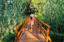 Woman walking on a wooden path during the Bus & Boat Trip to Krka National Park and Primošten with Swimming with Splitlicious Experiences.