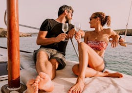 Couple drinking wine during their private Sunset Boat Trip from Fornells with Swimming Stops with Binimar Menorca.