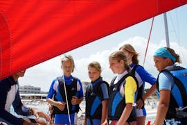 Some children listening to the explanations of their instructor in a family sailing course in Formentera from Es Pujols for beginners with Wet4Fun Formentera.