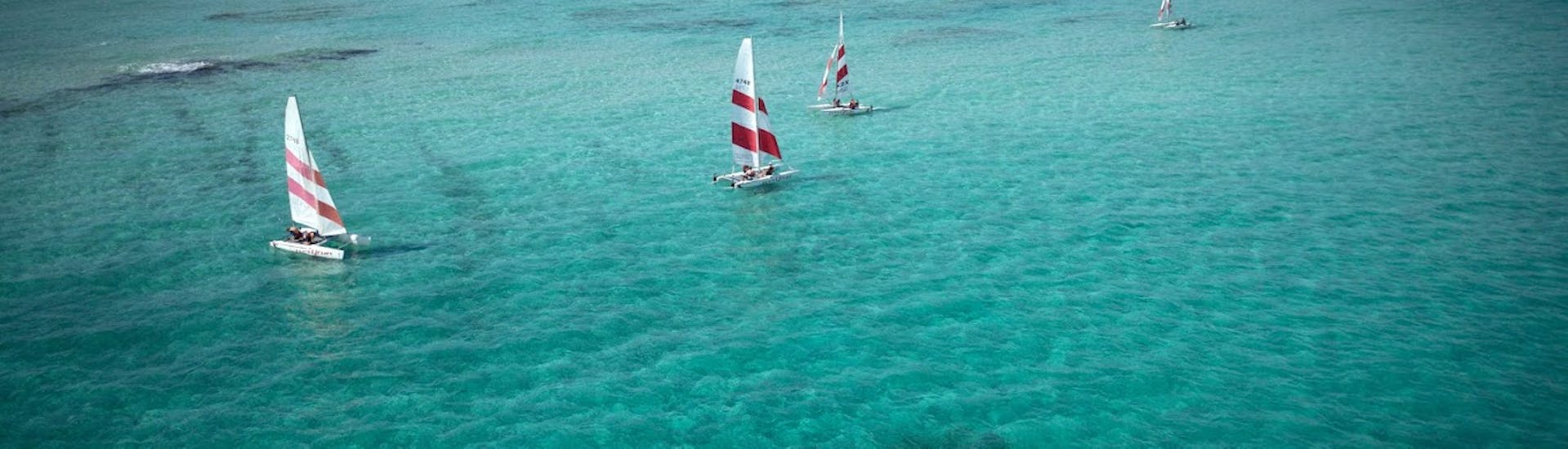 An aerial view of some of the sailing boats during a family sailing course in Formentera from Es Pujols for beginners with Wet4Fun Formentera.