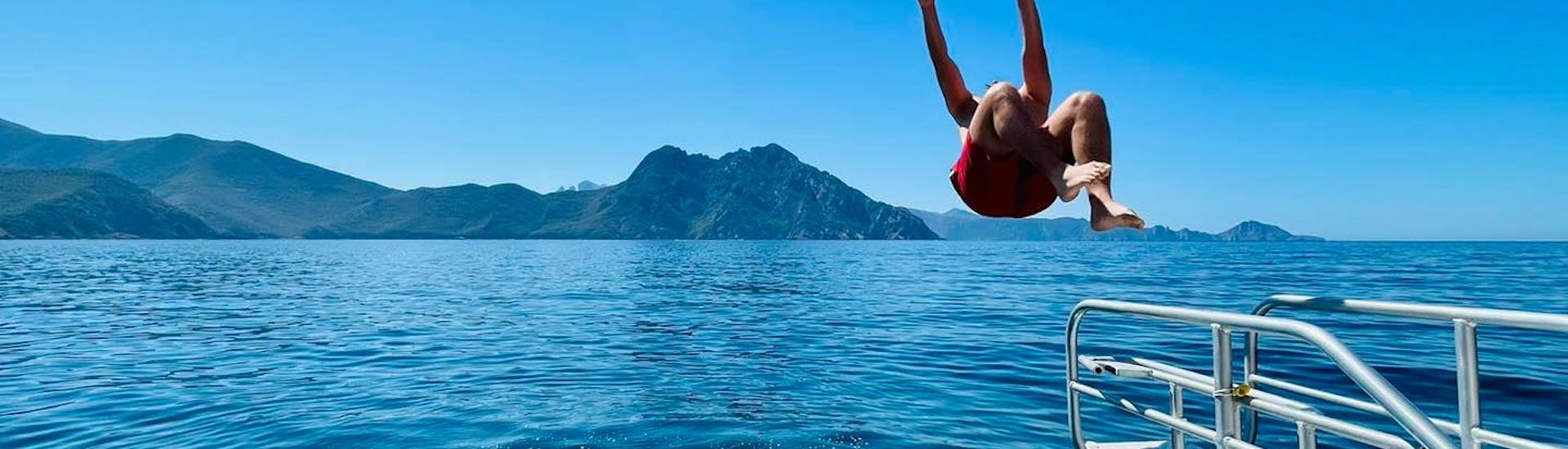 Person taking a dive during the boat trip via Scandola and Piana with a stopover in Calvi with Mare Bellu.
