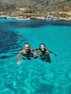 Due persone che fanno il bagno durante la Gita in gommone privato da Marsala a Favignana e Levanzo con pranzo e snorkeling con Calmapiatta Marsala.