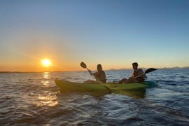 Unas personas durante la puesta de sol en una excursión guiada en kayak por la Bahía de Es Pujols y Punta Prima en Formentera con Wet4fun Formentera.
