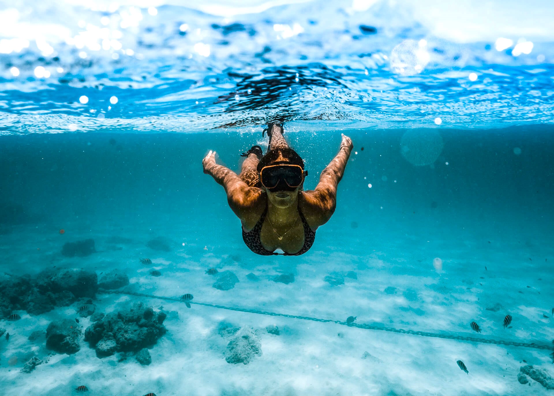 Una ragazza nuota, godendosi una delle bellissime soste per lo snorkeling durante la gita in catamarano intorno all'Arcipelago di La Maddalena con snorkeling da Baja Sardinia.
