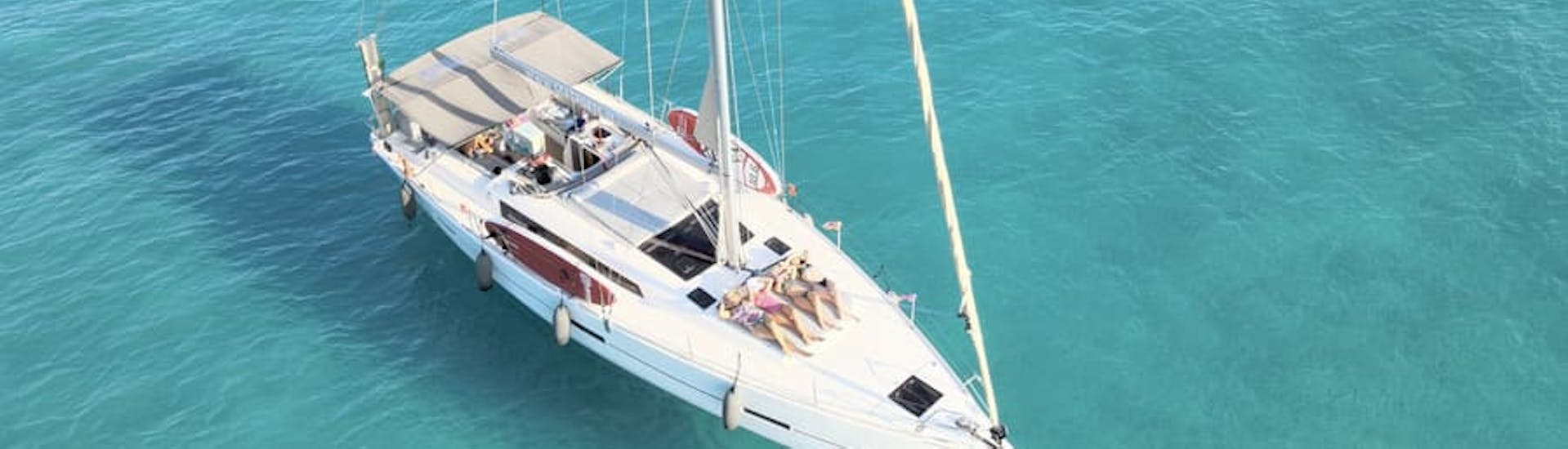 Alcune ragazze si abbronzano sulla barca durante il Gita in barca a vela privata da Tropea lungo la Costa degli Dei con Sea Sports Tropea.
