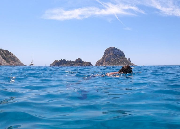Un niño hace snorkel durante la excursión en catamarán con fondo de cristal a Es Vedrà con snorkel y aperitivo con Capitán Nemo Ibiza.
