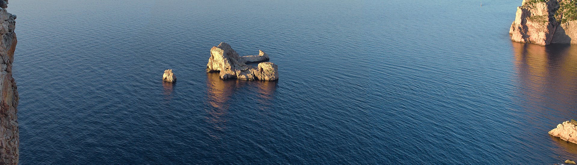 La vista desde el viaje en catamarán con fondo de cristal al acuario Cap Blanc con snorkel y aperitivo con el Capitán Nemo Ibiza.