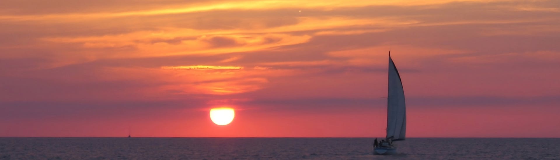 Un tramonto diverso durante uno dei viaggi di Katayak Menorca in barca a vela da Fornells con open bar al tramonto.