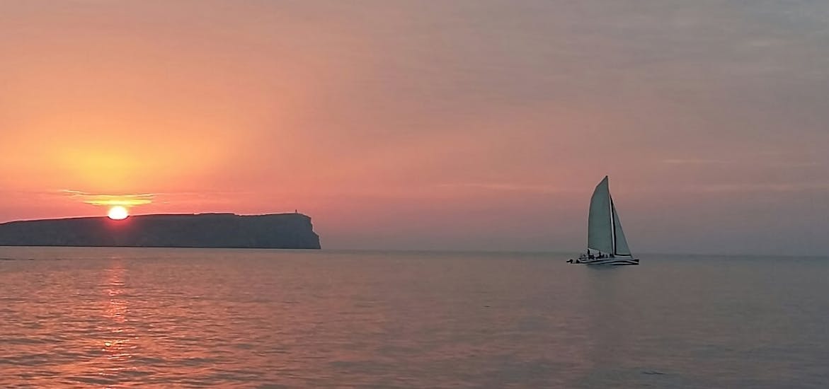 Vistas al atardecer de un paseo privado en catamarán desde Fornells por el norte de Menorca con barra libre al atardecer con Katayak Menorca.