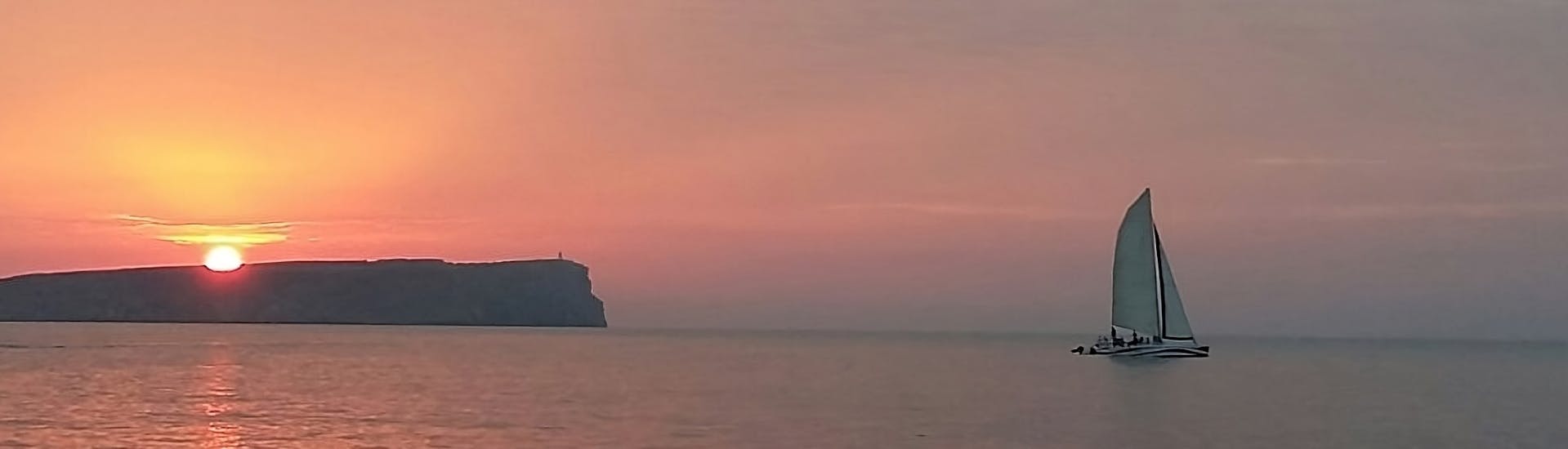 Vista a tramonto del Giro privato in catamarano al tramonto da Fornells lungo la costa nord di Minorca con open bar.